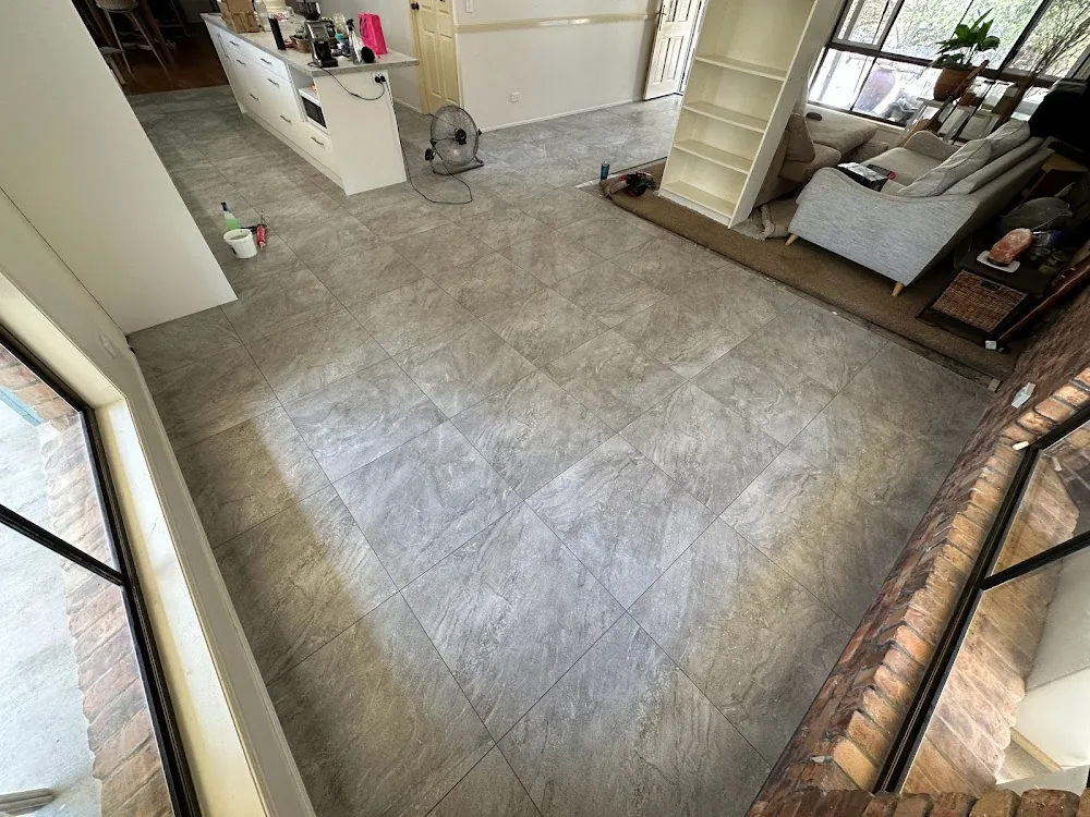 Large grey stone-look porcelain floor tiles laid through an open-plan kitchen and living room